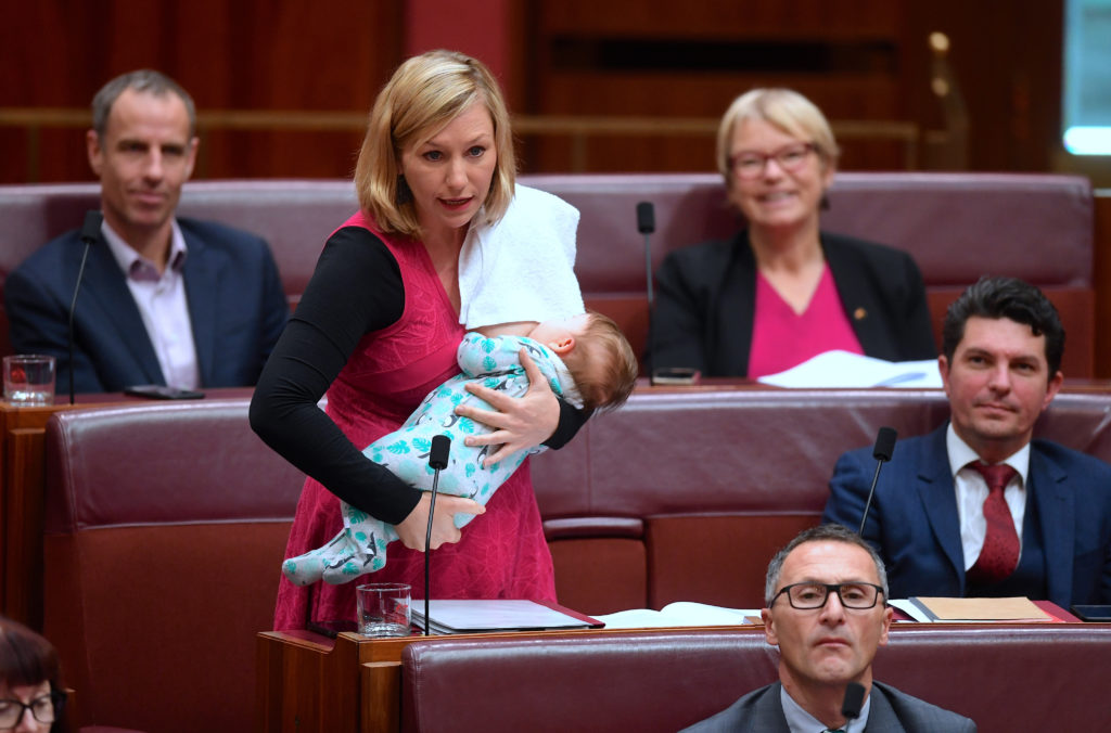 Den australiska senatorn Larissa Waters ammar sitt barn samtidigt som hon deltar i en debatt om skolfinansiering i parlamentet. REUTERS / TT