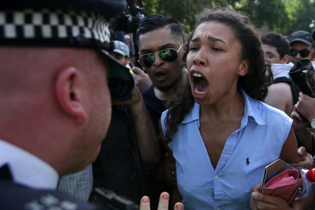 En kvinna skriker mot en polisman i London under en demonstration efter jättebranden i Grenfell Tower. AFP PHOTO / Daniel LEAL-OLIVAS / TT